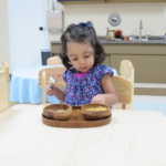 A little girl scooping corn kernels from one bowl to another (150x150)