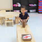 A little boy holding a wooden wheel
