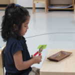 A little girl learning how to use a puncher (150x150)