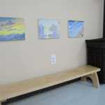 A bench and some paintings hung on the wall behind it (150x150)