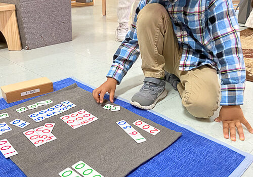 A boy playing with math placards