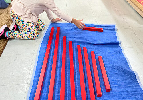 A child playing with wooden sticks of different sizes